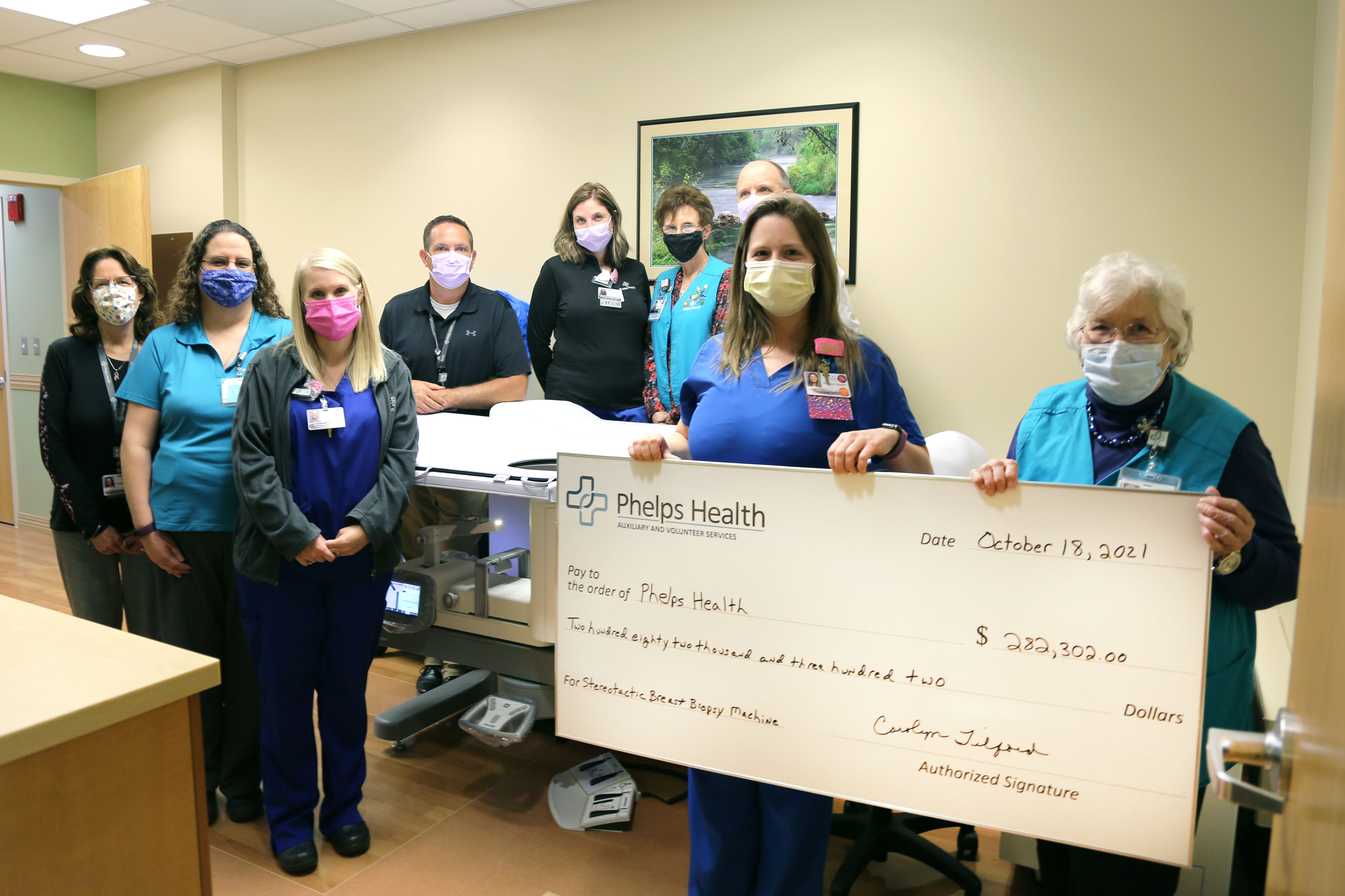 Phelps Health Auxilary and staff with stereotactic biopsy unit and donation check