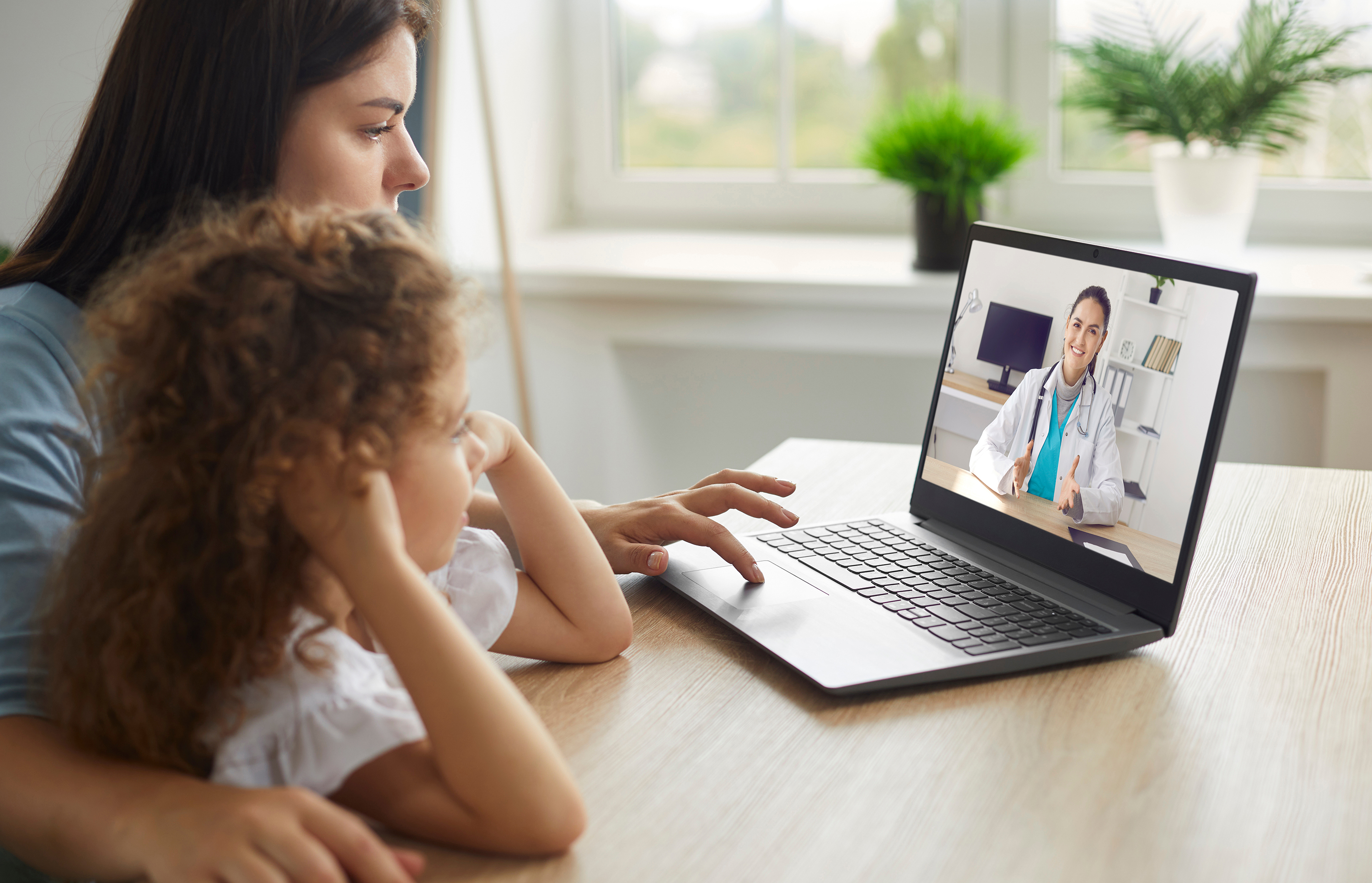 Woman and daughter receiving online care from telehealth provider