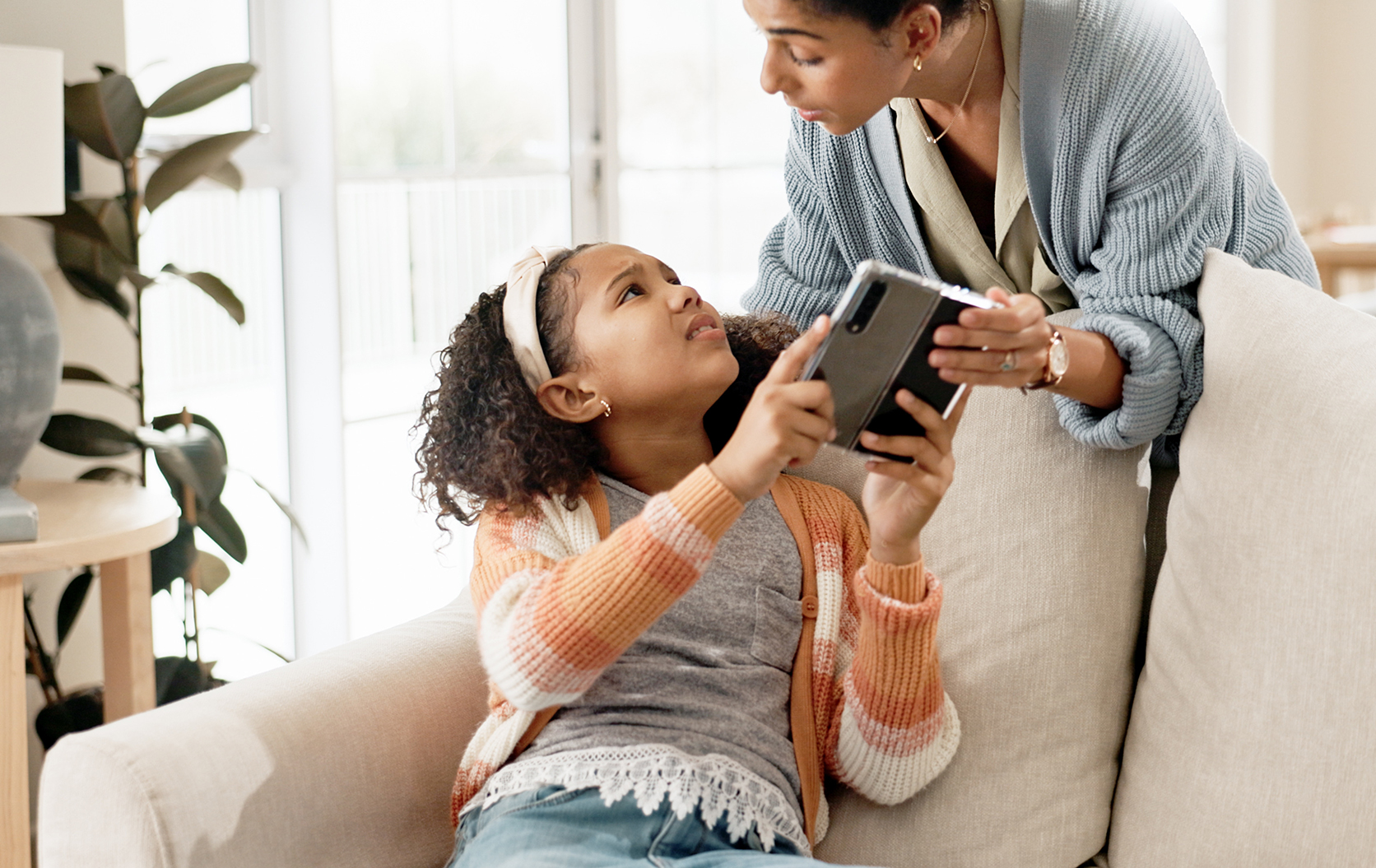 Child and parent battling over an electronic device