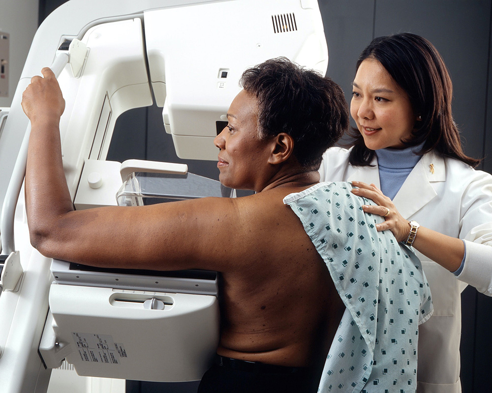 Technician performing a mammogram
