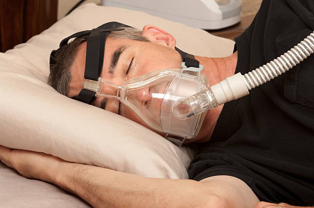 man sleeping with sleep apnea mask