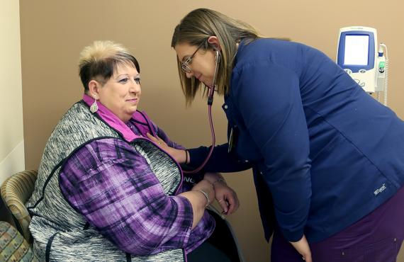 Nurse checking blood pressure of patient