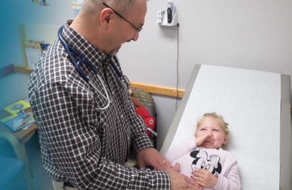 A physician assistant with a young female patient