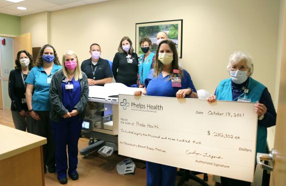 Phelps Health Auxilary and staff with stereotactic biopsy unit and donation check