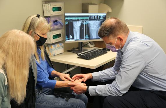 Brett Clayton, PA-C, examines a female patient's wrist. Brett Clayton, PA-C, examines a female patient's wrist.