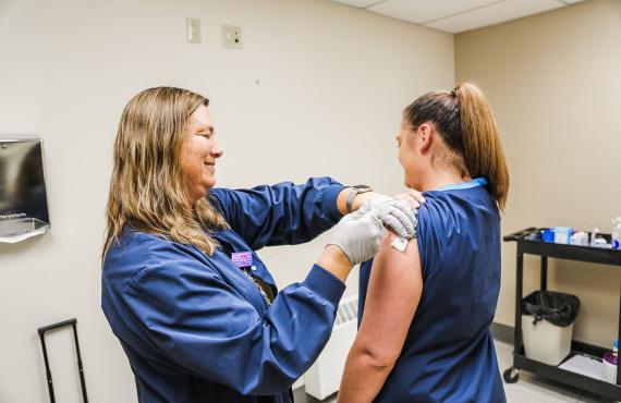 Nurse giving a woman a flu shot