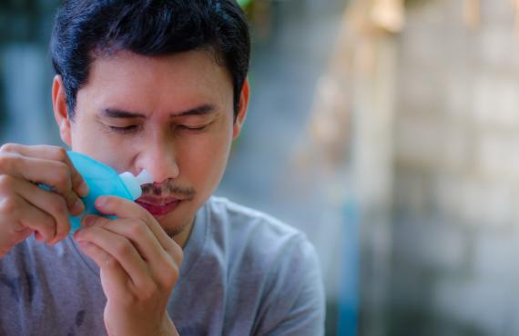 Man using a sinus rinse bottle