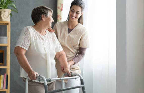 Nurse helping woman with walker