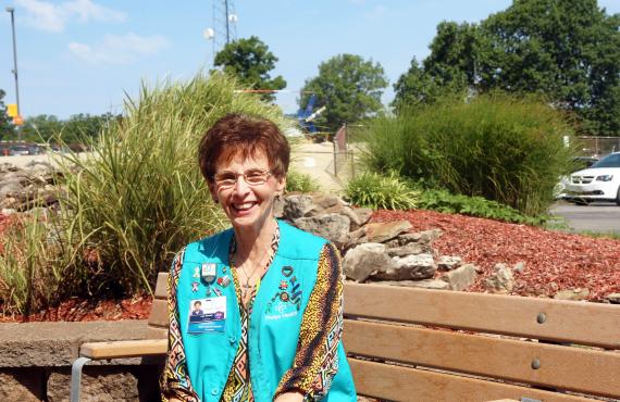 Volunteer Julie Schmidt sits on a bench