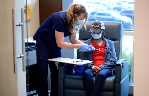 An infusion nurse gives a treatment to a patient