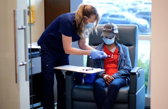 An infusion nurse gives a treatment to a patient An infusion nurse gives a treatment to a patient