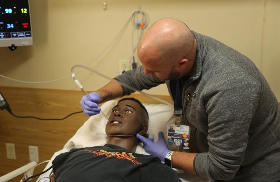 Nurse educator demonstrates training on manikin