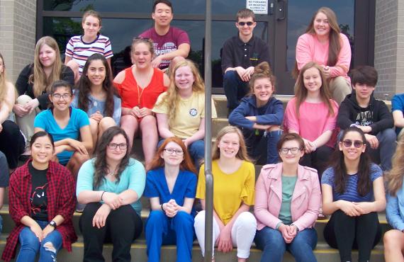 Large group of teenagers sitting on steps.