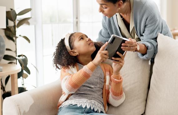 Child and parent battling over an electronic device